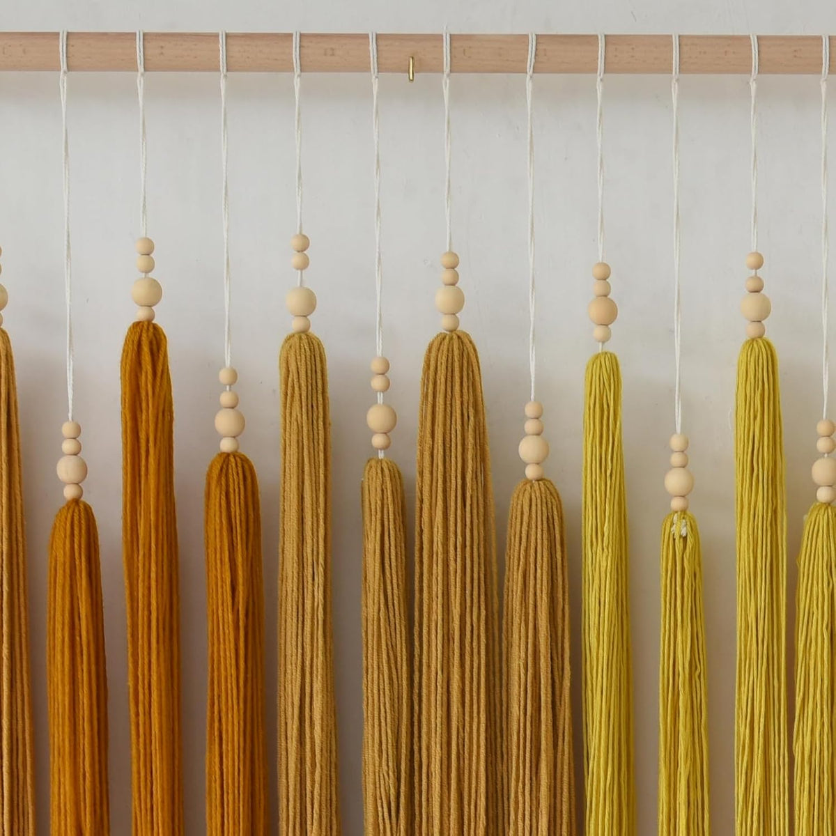 iower macrame wall hanging beaded tassel yarn art on a desk or shelf